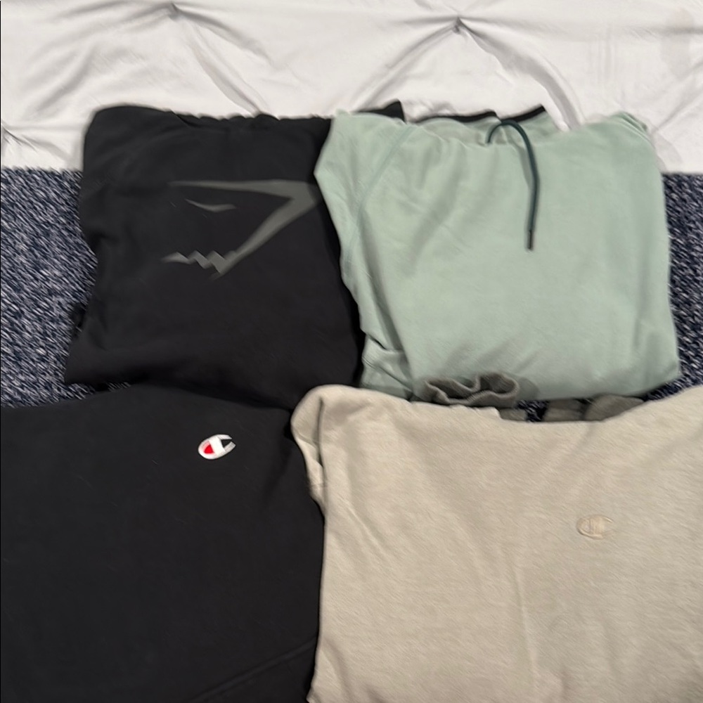 4 men's size medium hoodies (1 Gym Shark, 2 Chsmpion and 1 Reebok)